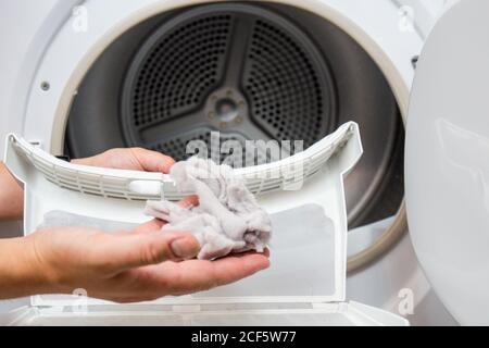 A housewife woman cleans the lint filter of the washing machine or tumble  dryer Stock Photo - Alamy