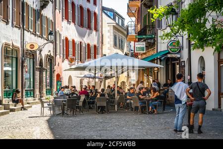 Sion Switzerland , 3 July 2020 : Bar terrace full of people on sunny summer day in pedestrian street of Sion old town Switzerland Stock Photo