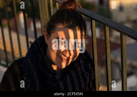 Pleased young lady with scarf on sunny day Stock Photo