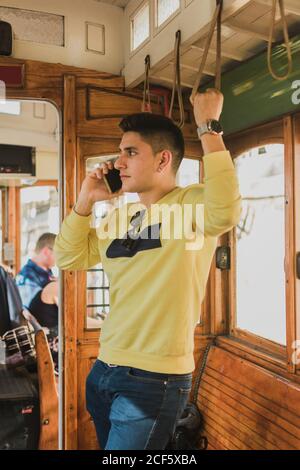Guy talking on phone riding in train Stock Photo