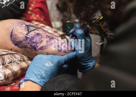 Tattooist working with client in salon Stock Photo
