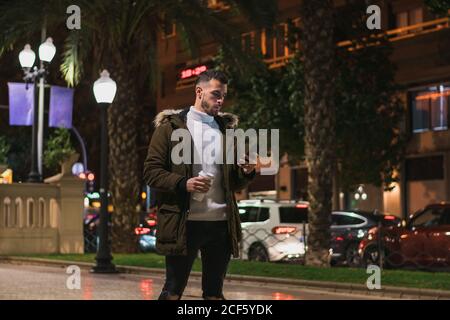 Serious young man using smartphone in street Stock Photo