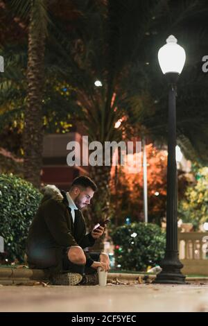 Serious young man using smartphone in street Stock Photo