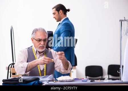 Young businessman visiting old tailor Stock Photo
