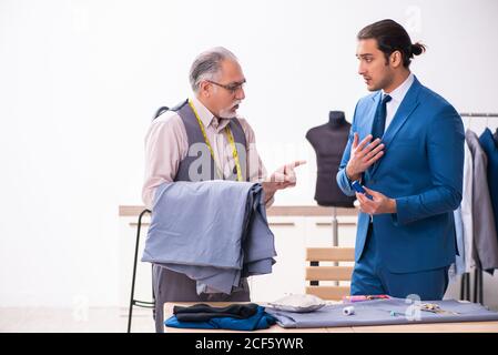 Young businessman visiting old tailor Stock Photo