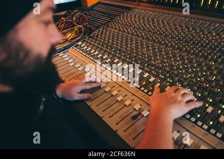 man musician working while playing in a equalizer instrument in a studio Stock Photo