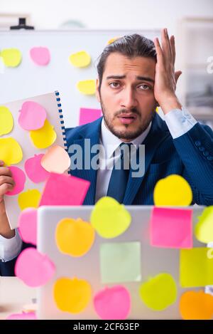 Young employee in conflicting priorities concept Stock Photo