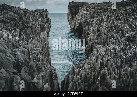 Breathtaking view of rocky cliffs against a turquoise sea on cloudy day Stock Photo