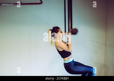 Young Woman doing pull ups in gym Stock Photo