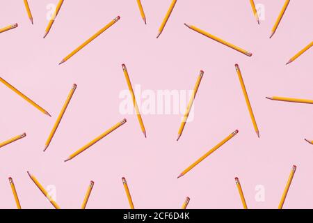 Top view of seamless background of pencils chaotically scattered on pink surface Stock Photo