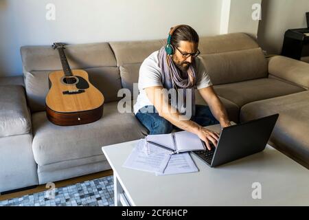 Focused man working with laptop in living room Stock Photo