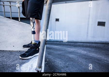 unrecognizable young man amputated with his leg prosthesis on an access ramp Stock Photo