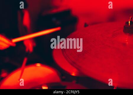 anonymous male holding drumsticks and playing on drums in redness Stock Photo