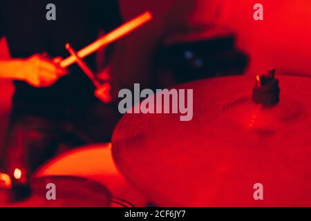 anonymous male holding drumsticks and playing on drums in redness Stock Photo