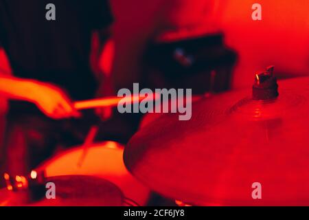 anonymous male holding drumsticks and playing on drums in redness Stock Photo