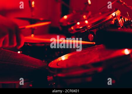 anonymous male holding drumsticks and playing on drums in redness Stock Photo