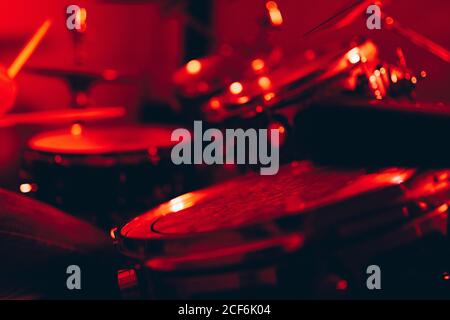 Side view of crop male holding drumsticks and playing on drums in redness Stock Photo