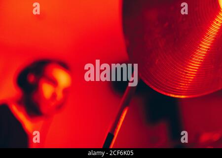 Side view of crop male holding drumsticks and playing on drums in redness Stock Photo