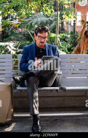 Aged handsome man using digital tablet outdoors Stock Photo