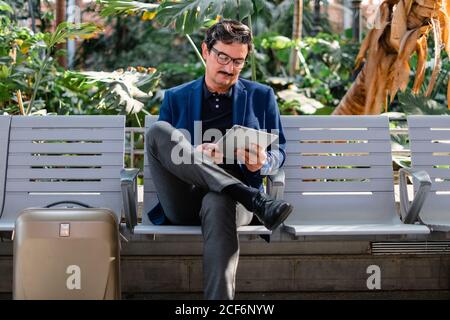 Aged handsome man using digital tablet outdoors Stock Photo