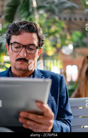 Aged handsome man using digital tablet outdoors Stock Photo