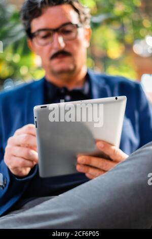 Aged handsome man using digital tablet outdoors Stock Photo