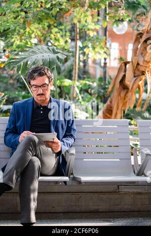 Aged handsome man using digital tablet outdoors Stock Photo