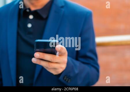 Senior businessman in blue jacket using smartphone Stock Photo
