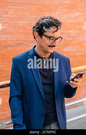 Senior businessman in blue jacket using smartphone Stock Photo