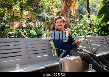 Aged handsome man using digital tablet outdoors Stock Photo