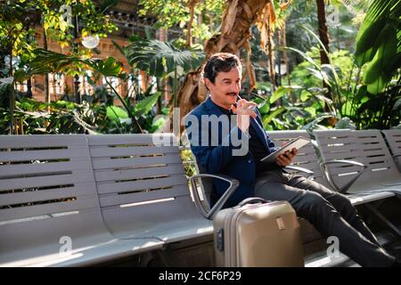 Aged handsome man using digital tablet outdoors Stock Photo