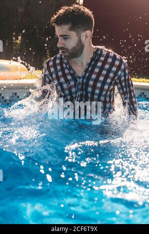 Dressed man in swimming pool Stock Photo