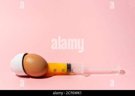 Egg with syringe in eggcup Stock Photo