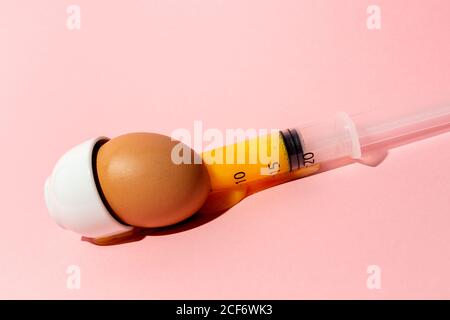 Egg with syringe in eggcup Stock Photo