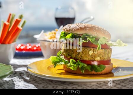 Homemade healthy vegan green lentil burger with tomato, lettuce and french fries with glass of red wine Stock Photo