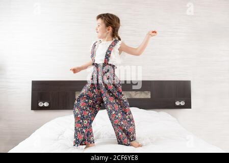Cheerful girl jumping on bed Stock Photo