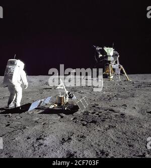 Astronaut Edwin E.'Buzz' Aldrin Jr., Lunar Module pilot, is photographed during the Apollo 11 extravehicular activity on the Moon. He has just deployed the Early Apollo Scientific Experiments Package (EASEP). In the foreground is the Passive Seismic Experiment Package (PSEP); beyond it is the Laser Ranging Retro-Reflector (LR-3); in the center background is the United States flag; in the left background is the black and white lunar surface television camera; in the far right background is the Lunar Module 'Eagle'. Astronaut Neil A. Armstrong, commander, took this photograph with a 70mm lunar s