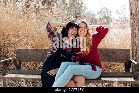 Young women sitting on bench and looking at camera Stock Photo