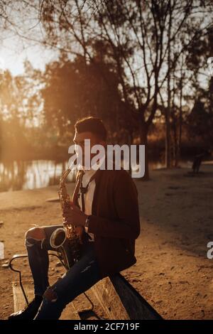 young musician playing the saxophone at sunset Stock Photo