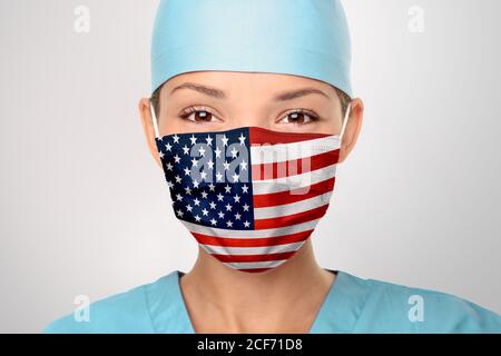 USA American doctor wearing Coronavirus pandemic COVID-19 mask in the United States of America. American flag print on Asian woman doctor's mask Stock Photo
