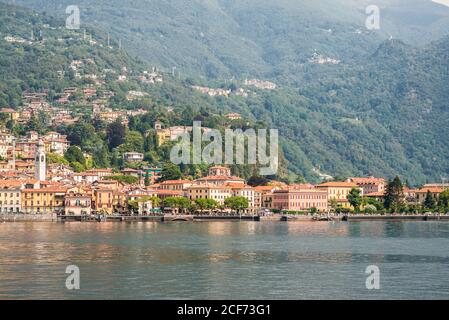 Panorama of Menaggio Town on Lake Como in Italy. Bright Architecture with Colorful Buildings. City Embankment with Tourists. View from Water. Stock Photo