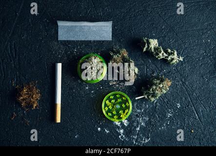 Top view of dried cannabis buds and rolling paper with cigarette on grunge surface Stock Photo