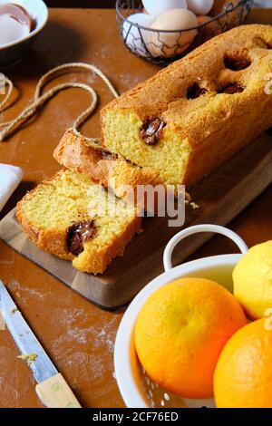 From above sliced of yummy sponge chocolate cake on towel on table in kitchen Stock Photo