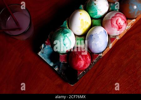 Set of painted Easter eggs in container on table Stock Photo