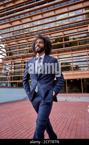 Ethnic businessman standing at street Stock Photo