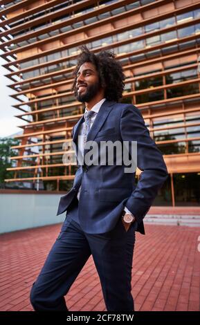 Ethnic businessman standing at street Stock Photo