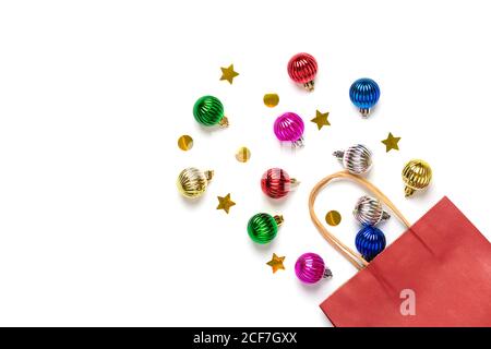 Christmas - tree decorations colorful bauble, glitters crumbled from red paper bag isolated on white background Flat lay Top view Holiday card Merry Stock Photo