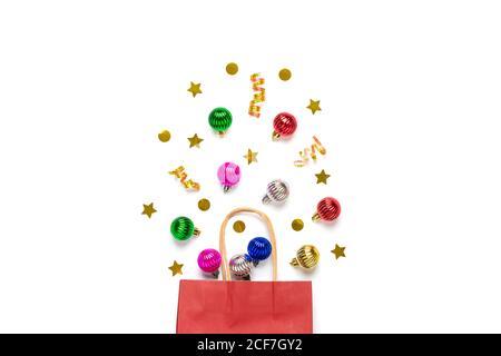 Christmas - tree decorations colorful bauble, glitters crumbled from red paper bag isolated on white background Flat lay Top view Holiday card Merry Stock Photo