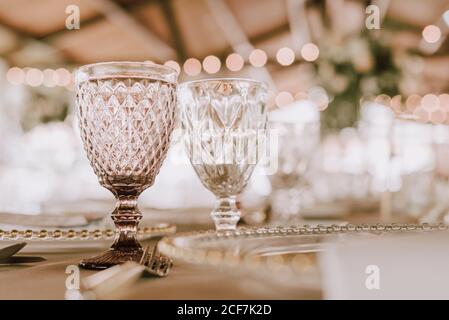 Beautiful empty wineglasses on banquet table on blurred background in modern restaurant Stock Photo