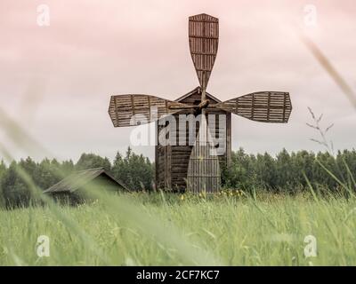 Engaging old wooden windmill on border of field and forest in Finland Stock Photo